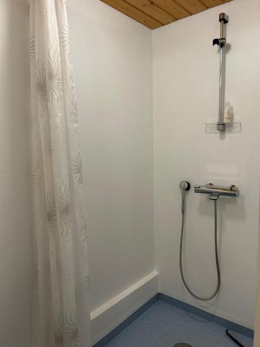 a shower in a bathroom with a shower curtain at Tunnelmallinen maalaistaloelämys in Vehmaa
