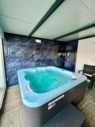 una grande vasca da bagno blu in una stanza di Skyline Gozo Penthouse with Jacuzzi a Xagħra