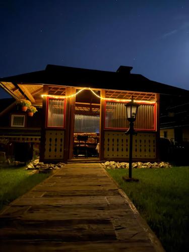 a house with lights on the front of it at night at Penzión Stodola in Ždiar