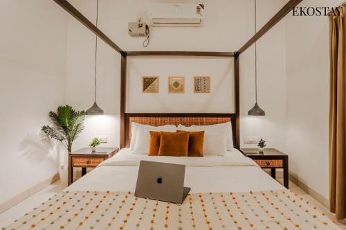 a bedroom with a bed with a laptop on it at EKOSTAY Luxe - Oceanic Villa in Alibaug