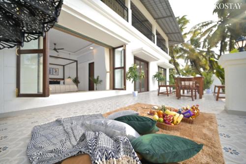 a living room with a couch and pillows on the floor at EKOSTAY Luxe - Oceanic Villa in Alibaug