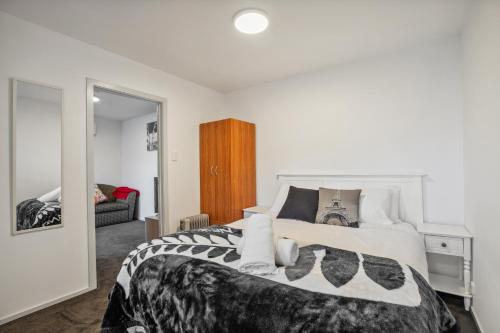 a bedroom with a large bed with white sheets and pillows at Arawata Retreat - Queenstown Mountain Serenity in Queenstown