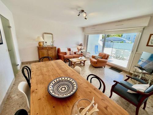 un salon avec une table et des chaises en bois dans l'établissement Quiberon - Appartement T3 de 65m² en rez-de-chaussée avec terrasse, proche plage et stationnement - FR-1-478-217, à Quiberon
