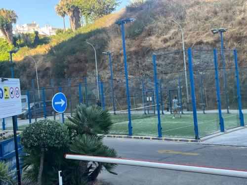 a tennis court with blue poles on a field at Benalmadena Suite Vistas panorámicas, 2 piscinas, Area infantil, Bar, Jardines y Tenis in Benalmádena