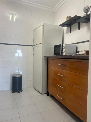 a kitchen with a refrigerator and a counter top at Benalmadena Suite Vistas panorámicas, 2 piscinas, Area infantil, Bar, Jardines y Tenis in Benalmádena