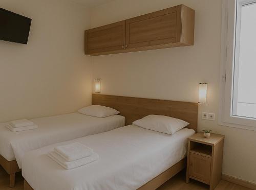 two beds sitting next to each other in a room at Résidence Molière Hôtel Paris Montrouge in Montrouge