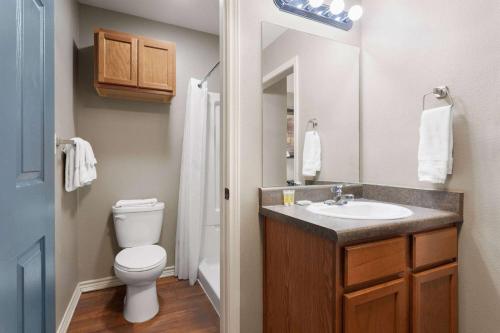 a bathroom with a white toilet and a sink at Eagle's Den Three Rivers Texas a Travelodge by Wyndham in Three Rivers