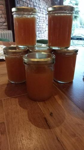 un gruppo di barattoli di miele su un tavolo di legno di L'ACADEMIE a Leynes