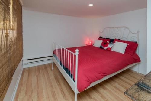 a bedroom with a bed with a red blanket at Traversier Gratuit- Aux Trois Filles in Lévis
