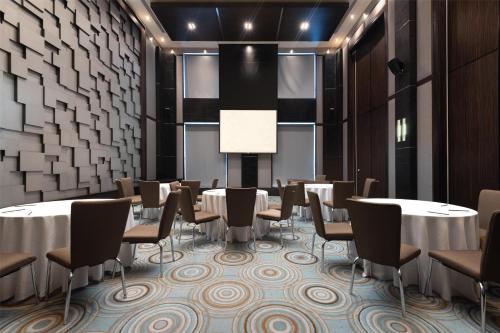 a conference room with tables and chairs and a screen at Radisson Blu Hotel, Dubai Media City in Dubai