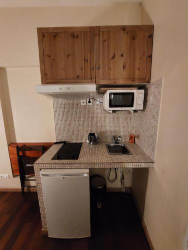 a small kitchen with a sink and a microwave at Résidence Molière Hôtel Paris Montrouge in Montrouge
