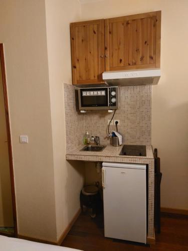 a small kitchen with a sink and a microwave at Résidence Molière Hôtel Paris Montrouge in Montrouge