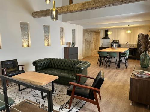 un salon avec un canapé et une table dans l'établissement Le loft du Cloître - Parking - Clim, à Avignon