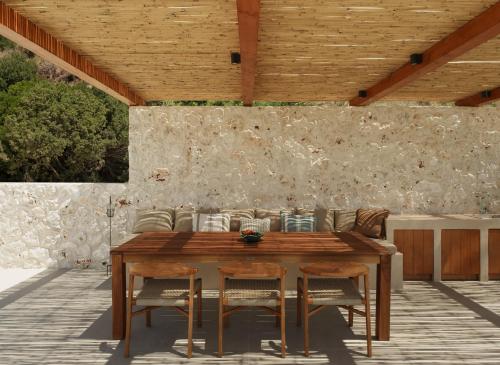 a wooden table and chairs on a patio at Sundara Estate, Exclusive Seaview Villa with Grand Pool & Direct Beach Access in Ratzaklíon
