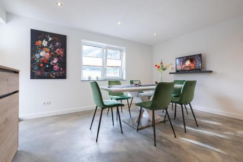 a dining room with a table and green chairs at Haus Paul in Kals am Großglockner