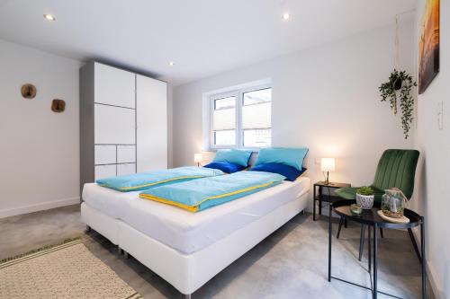 a bedroom with a large white bed with blue pillows at Haus Paul in Kals am Großglockner