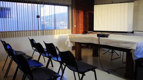 um quarto com uma mesa e cadeiras e um ecrã em Pousada Canto da Baleia em Arraial do Cabo