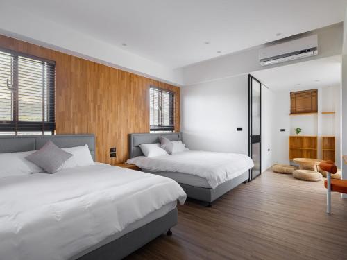 a bedroom with two beds and a table at 巷往 villa in Dongshan