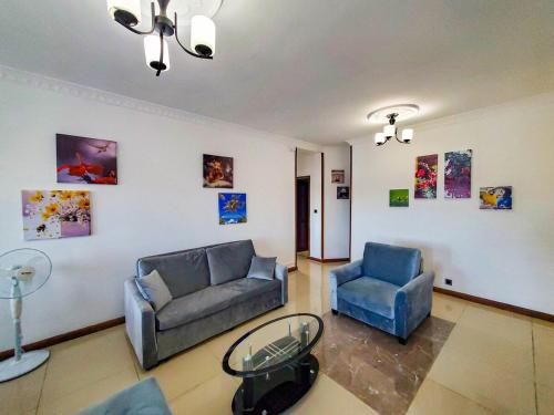 a living room with two couches and a glass table at Les Alizés appartement 4 in Toamasina