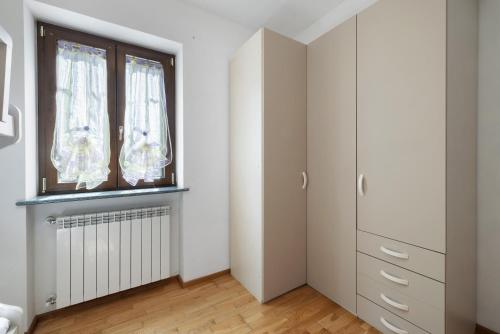 a bedroom with white cabinets and a window at La Casa Sul Lago in Osiglia