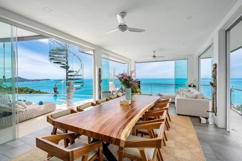 a dining room with a table and chairs and a view of the ocean at Villa Seawadee - luxurious, award-winning design Villa with amazing panoramic seaview in Chaweng Noi Beach