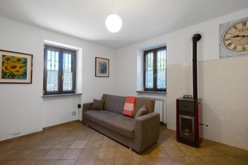 a living room with a couch and a clock on the wall at La Casa Sul Lago in Osiglia