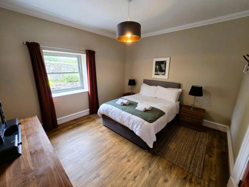 a bedroom with a large bed and a window at Balmory Stables North, luxury stable conversion in Ascog