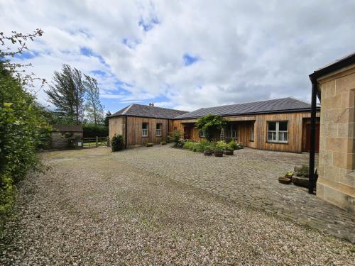 a house with a gravel driveway in front of it at Balmory Stables North, luxury stable conversion in Ascog