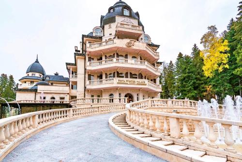 un grande edificio con un ponte di fronte a una fontana di Festa Winter Palace Hotel a Borovets