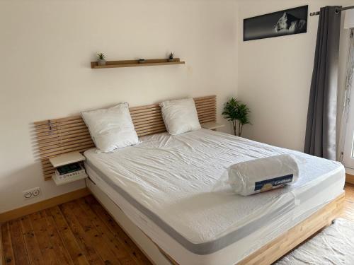 a bedroom with a large bed with white sheets at Maison de ville avec jardin clos 4 Pers in Saint-Pol-de-Léon