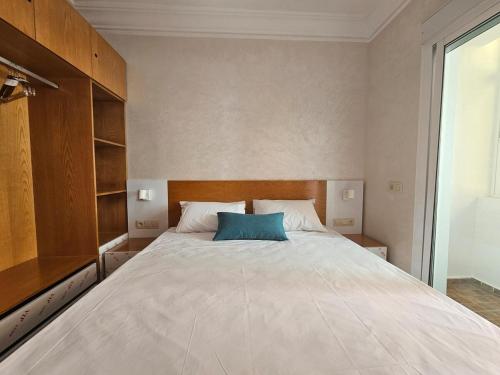 a bedroom with a large bed with a blue pillow at El Rincón Bonito in Tetouan