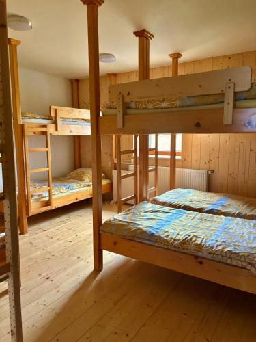 a room with three bunk beds in a cabin at DOMŽALSKI DOM na Veliki Planini in Stahovica