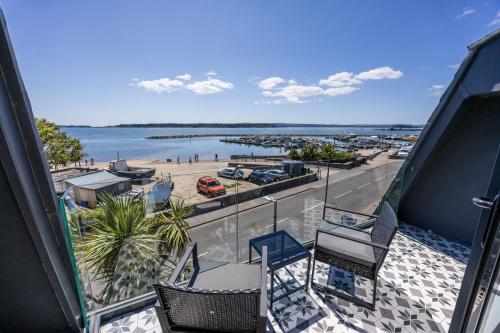 a balcony with chairs and a view of a beach at Candle Island View - Superb Harbour Views from Three Floors in Poole