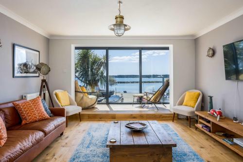 a living room with a couch and a table at Candle Island View - Superb Harbour Views from Three Floors in Poole
