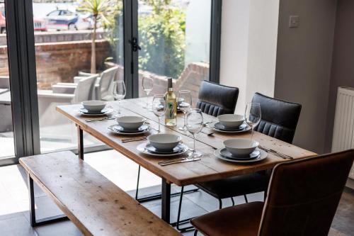 a wooden table with chairs and a bottle of wine at Candle Island View - Superb Harbour Views from Three Floors in Poole