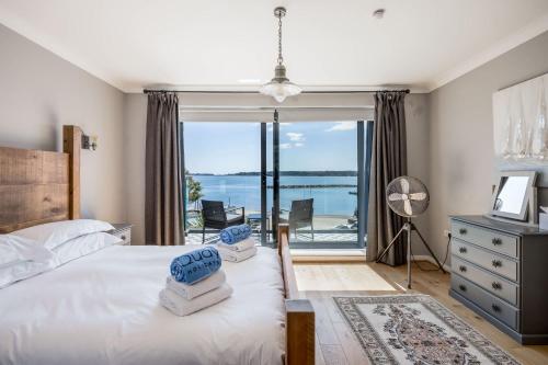 a bedroom with a bed and a view of the water at Candle Island View - Superb Harbour Views from Three Floors in Poole