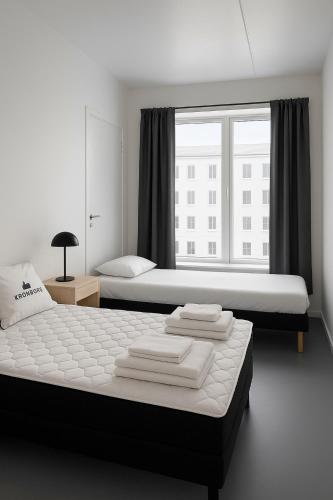a bedroom with two beds and a large window at Talle-Central Apartment Odense C in Odense
