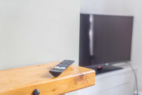 a remote control sitting on top of a wooden table at Lovely Lindisfarne in Carlisle