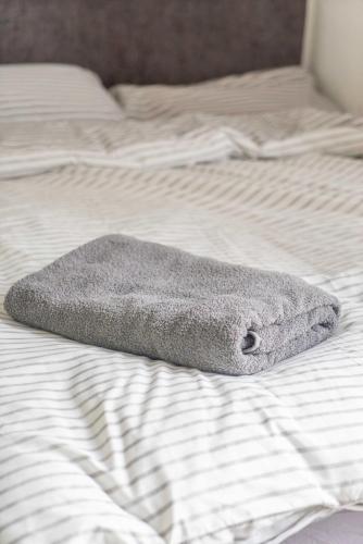 a gray towel is laying on a bed at Lovely Lindisfarne in Carlisle