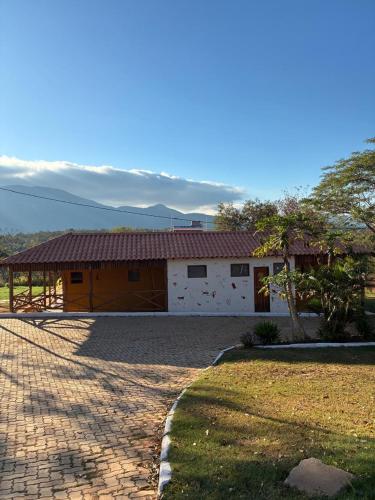 a house with a brick driveway in front of it at Pousada Lapa Rupestre in Santana do Riacho
