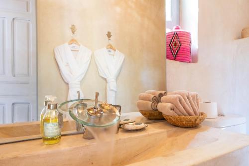 a bathroom with a counter with a mirror and a white suit on display at Dar Syada Boutique Hotel Marrakech in Marrakech