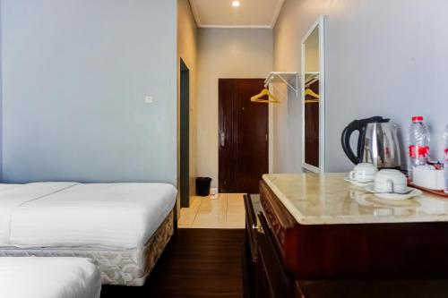 a hotel room with a bed and a counter top at Townhouse Oak Syariah Hotel Binjai in Medan
