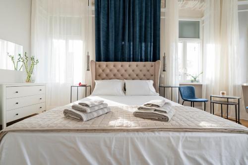 a bedroom with a large bed with towels on it at Agora apartment in Ermoupoli