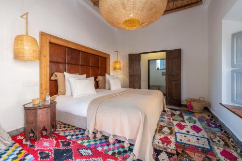 a bedroom with a large bed and a rug at Dar Syada Boutique Hotel Marrakech in Marrakech