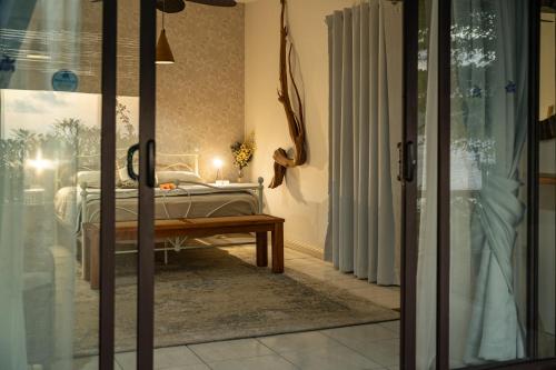 a bedroom with a bed and a glass door at Beach House Beau Vallon in Beau Vallon