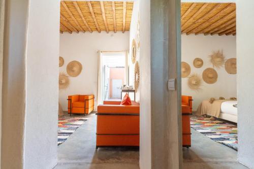 a living room with orange furniture and a bed at Dar Syada Boutique Hotel Marrakech in Marrakech