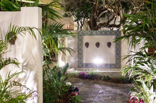 a garden with plants and a wall with a window at Carmel Pearl in Haifa