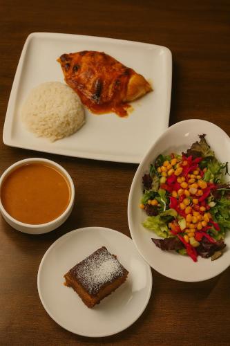 a table with two plates of food with rice and vegetables at Pera Tulip Hotel & Spa - Istanbul Taksim Pera City Center in Istanbul