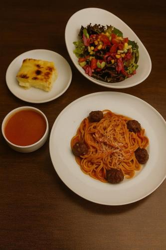 a table with three plates of pasta and a salad at Pera Tulip Hotel & Spa - Istanbul Taksim Pera City Center in Istanbul