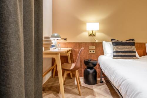 a hotel room with a bed and a desk and a bed and a bedskirts at Hostal Ambos Mundos in Barcelona
